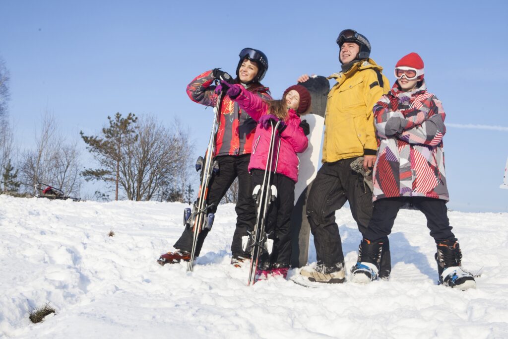 スキー道具を持つ家族